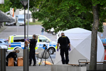 Policajti pracujú na mieste po streľbe vo Farsta na juhu Štokholmu vo Švédsku. FOTO: Reuters