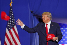Bývalý americký prezident Donald Trump hádže šiltovku Save America, keď sa zúčastňuje zhromaždenia vo Warrene. FOTO: Reuters