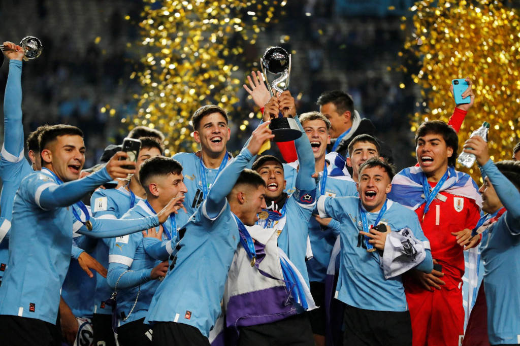 Uruguajčan Fabricio Diaz a jeho spoluhráči oslavujú s trofejou po víťazstve na majstrovstvách sveta hráčov do 20 rokov. FOTO: Reuters