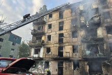 Pr&iacute;slu&scaron;n&iacute;ci z&aacute;chrann&yacute;ch zložiek hasia požiar na viacposchodovom bytovom dome po ruskom raketovom &uacute;toku na mesto Kryvyj Rih v strednej časti Ukrajiny. FOTO: TASR/AP
