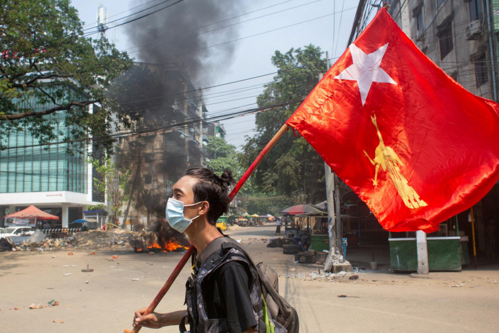 Muž drží vlajku Národnej ligy za demokraciu počas protestu proti vojenskému prevratu v Yangone v Mjanmarsku. FOTO: Reuters