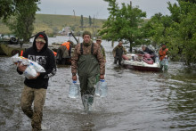 Ukrajinskí vojaci vykladajú humanitárnu pomoc pre miestnych obyvateľov po pretrhnutí priehrady Nova Kakhovka v zatopenej dedine Afanasiivka v Chersonskej oblasti. FOTO: Reuters