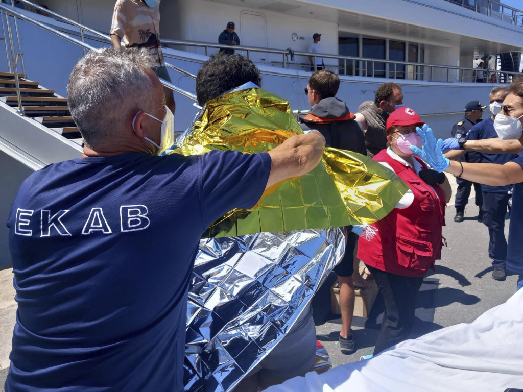 Záchranári poskytujú migrantom prvú pomoc počas záchrannej akcie v gréckom prístavnom meste Kalamata. FOTO: TASR/AP
