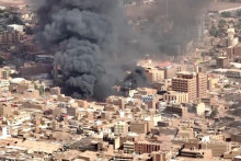 Čierny dym a plamene na trhu v Sudáne. FOTO: Reuters
