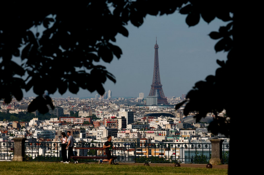 Ľudia sa tešia pohľadom na baziliku Sacre-Coeur na Montmartre a Eiffelovu vežu v Parc de Saint-Cloud neďaleko Paríža. FOTO: Reuters