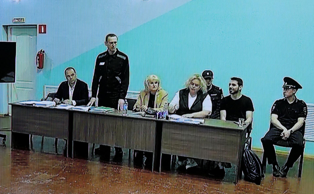 Pohľad na obrazovku, na ktorej je zobrazený ruský opozičný vodca Alexej Navaľnyj (druhý vľavo) medzi svojimi právnikmi v súdnej sieni prostredníctvom video spojenia počas predbežného pojednávania v Melechove. FOTO: Reuters
