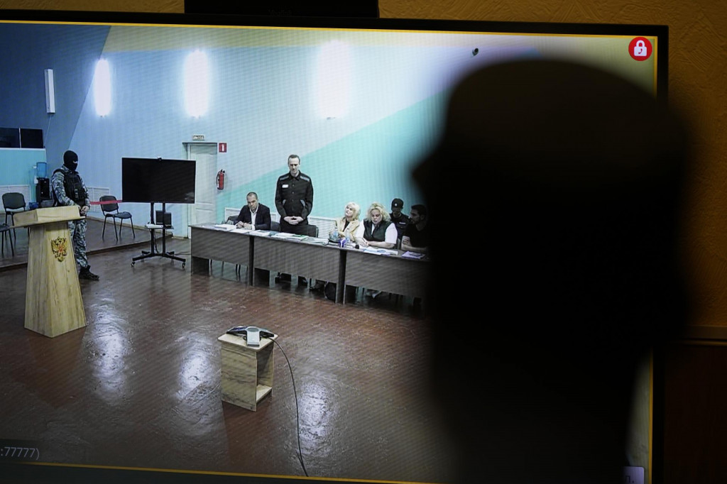 Strážnik sleduje videoprenos z nového súdneho procesu s väzneným ruským opozičným vodcom Alexejom Navaľným (tretí zľava). FOTO: TASR/AP
