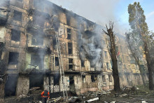 Príslušníci záchranných zložiek hasia požiar na viacposchodovom bytovom dome po ruskom raketovom útoku na mesto Kryvyj Rih v strednej časti Ukrajiny v utorok 13. júna 2023. FOTO: TASR/AP