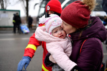 Žena bozkáva svoje dieťa po úteku z Ukrajiny na hraničnom priechode v rumunskom meste Siret. FOTO: Reuters