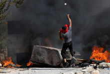 Palestínčan hádže kameňom počas stretov s izraelskými jednotkami po útoku izraelských osadníkov na dedinu Umm Safa neďaleko Ramalláhu na Izraelom okupovanom Západnom brehu Jordánu. FOTO: Reuters