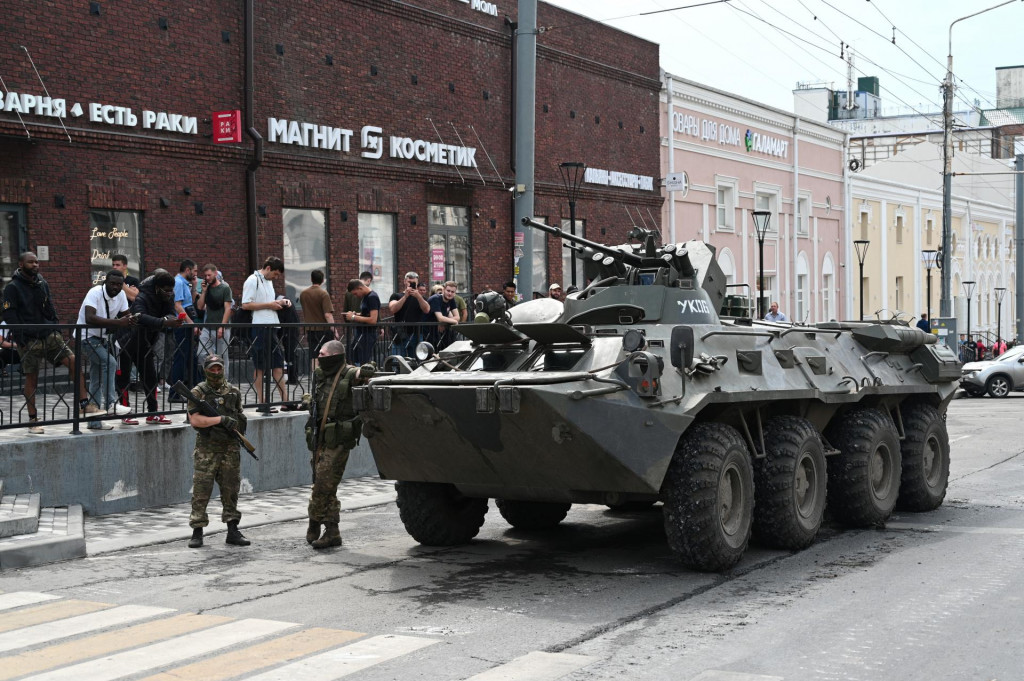 Bojovníci Wagnerovej skupiny stoja vedľa obrneného vozidla na ulici v meste Rostov na Done. FOTO: Reuters