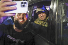 Ruský občan si robí ”selfie” s vodcom Wagnerovej skupiny Jevgenijom Prigožinom na ulici v Rostove, ktorý žoldnieri obsadili. Záber vznikol počas Prigožinovho odjazdu z mesta. FOTO: TASR/AP
