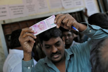 Muž drží 2000 indických rupií. FOTO: Reuters