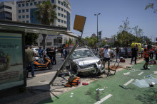 Izraelské bezpečnostné jednotky zasahujú po tom, čo palestínsky útočník narazil autom úmyselne do ľudí na autobusovej zastávke v Tel Avive. FOTO: TASR/AP