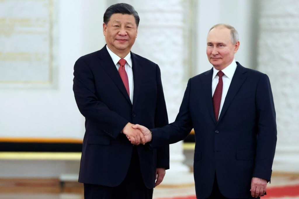 Ruský prezident Vladimir Putin si podáva ruku s čínskym prezidentom Si Ťin-pchingom. FOTO: TASR/AP