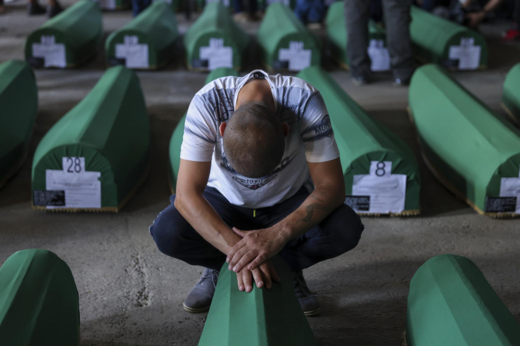 Moslimský muž plače pri truhle s pozostatkami príbuzného, obete masakry v Srebrenici. FOTO: TASR/AP