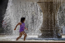 Dievča beží vo fontáne pri Starej opere počas horúceho dňa vo Frankfurte nad Mohanom. FOTO: TASR/AP