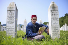 Bosniak sa modlí pri hroboch svojich príbuzných na pamätnom cintoríne v bosnianskej obci Potočari, ktorá sa nachádza neďaleko Srebrenice. FOTO: TASR/AP