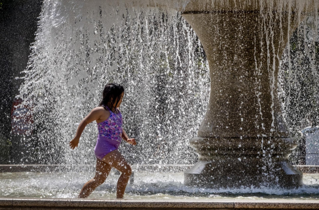 Dievča beží vo fontáne pri Starej opere počas horúceho dňa vo Frankfurte nad Mohanom. FOTO: TASR/AP