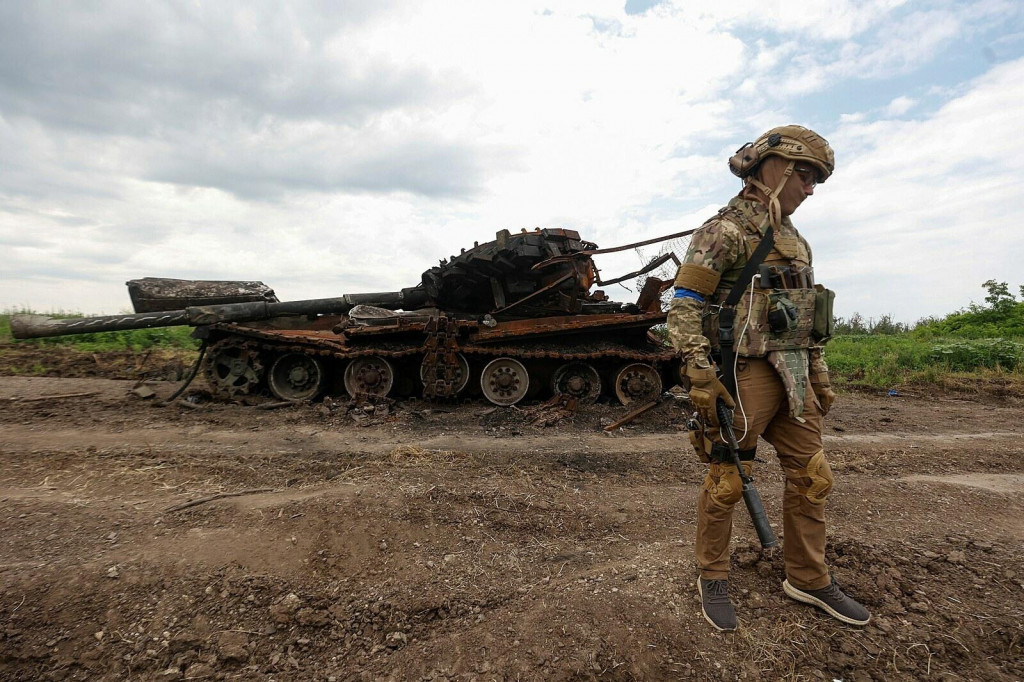 Ukrajinský vojak kráča vedľa zničeného ruského tanku v nedávno dobytej dedine Novodarivka. FOTO: Reuters