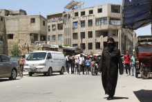 Ľudia kráčajú po ulici v meste Douma v Sýrii. FOTO: Reuters