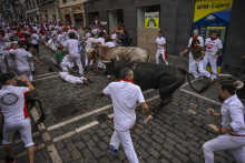 Ľudia utekajú pred býkmi počas ôsmeho dňa behu s býkmi ulicami severošpanielskeho mesta Pamplona. FOTO: TASR/AP