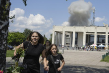 Ženy utekajú počas ruského raketového útoku na mesto Pervomajskyj v Charkovskej oblasti. FOTO: TASR/AP