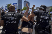 Izraelskí policajti zadržali demonštrantku počas ďalšieho protestu proti vládnemu návrhu súdnej reformy izraelského premiéra Benjamina Netanjahua v Tel Avive. FOTO: TASR/AP
