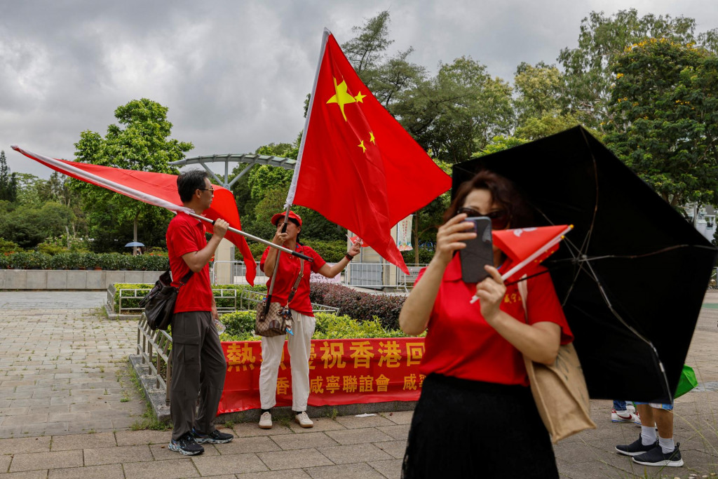 

Ľudia mávajú čínskymi a hongkonskými vlajkami na podujatí FOTO: Reuters