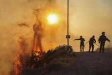 Hasiči sa  pokúšajú uhasiť lesný požiar v Saronide neďaleko Atén v Grécku. FOTO: Reuters