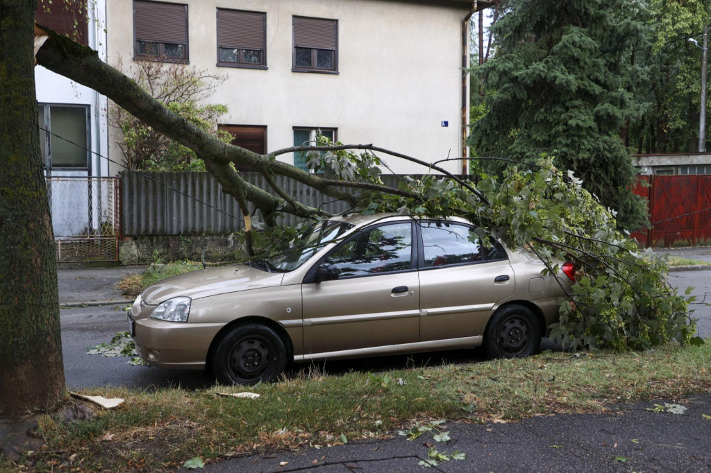 Zlomený konár stromu spadol na zaparkované auto počas silnej búrky v Záhrebe. FOTO: TASR/AP
