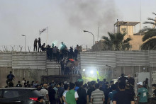 Protestujúci stoja na múre švédskeho veľvyslanectva v Bagdade. FOTO: TASR/AP
