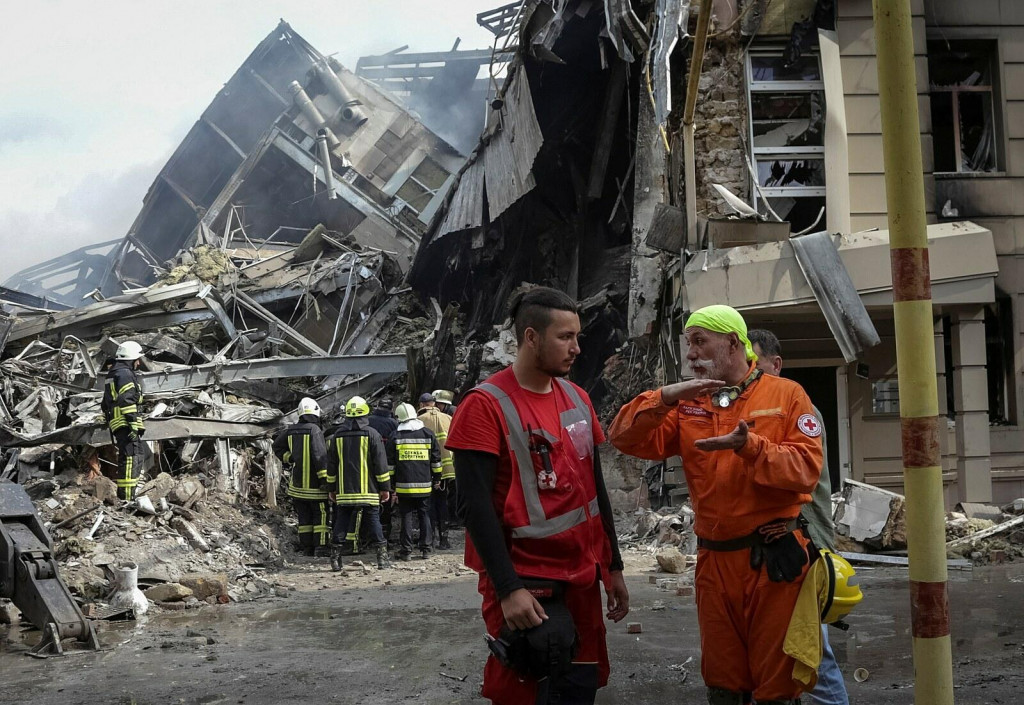 Ukrajinskí hasiči a záchranári pracujú na mieste zničenej budovy po ruskom raketovom útoku v Odese. FOTO: Reuters