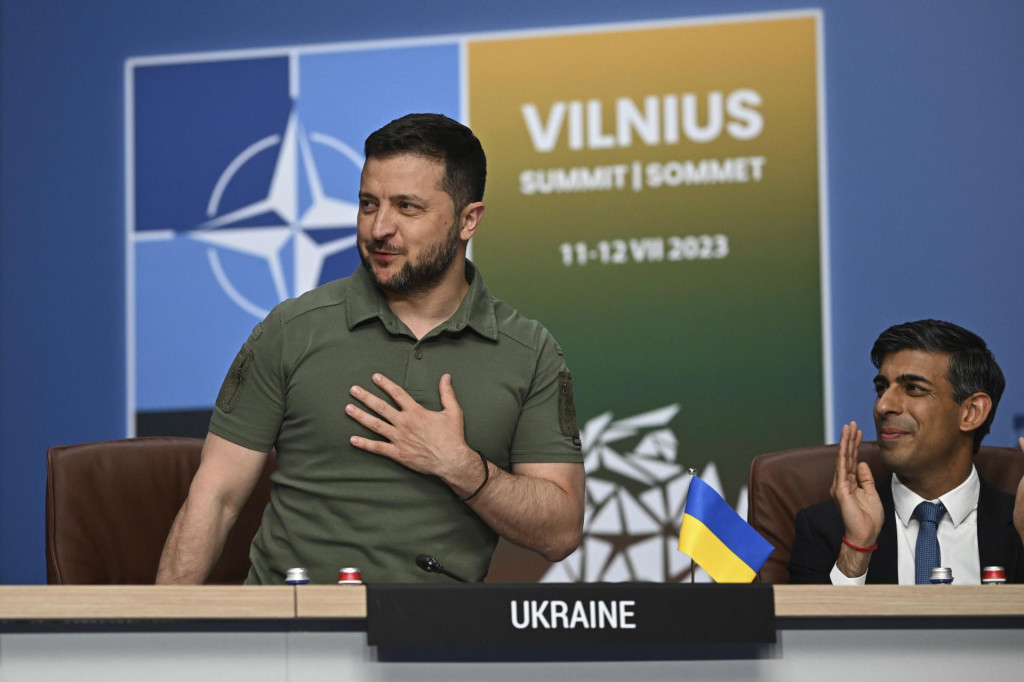 Ukrajinský prezident Volodymyr Zelenskyj (vľavo) reaguje pri potlesku britského premiéra Rishiho Sunaka počas stretnutia Rady NATO - Ukrajina na summite NATO vo Vilniuse. FOTO: TASR/AP