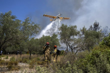 Lietadlo hasí lesný požiar v obci Vati na ostrove Rodos na juhovýchode Grécka. FOTO: TASR/AP