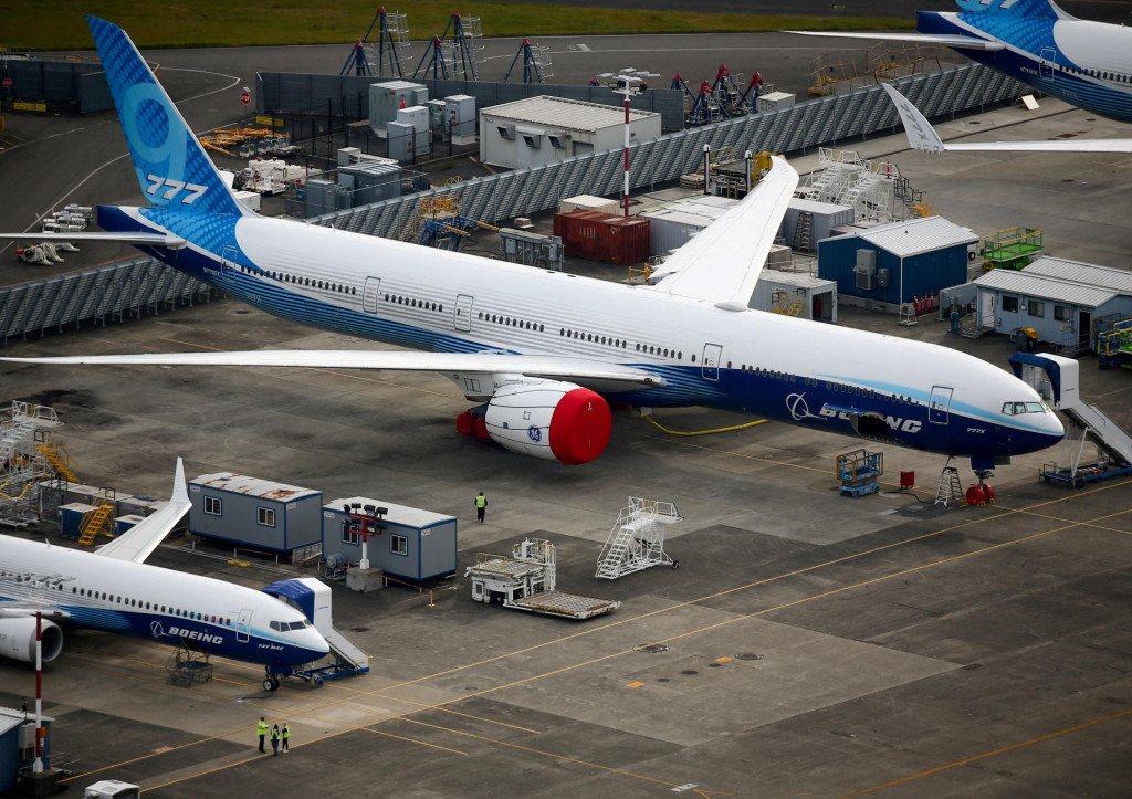Pracovníci kráčajú v blízkosti lietadiel Boeing 737 MAX10 a Boeing 777X. FOTO: Reuters