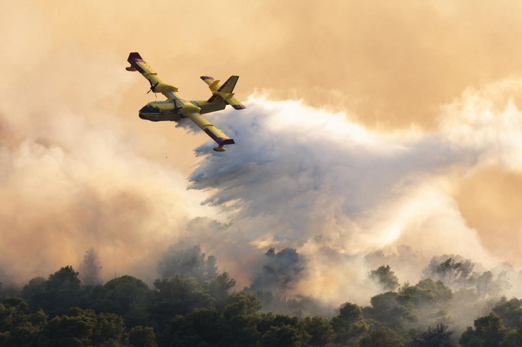 Hasičské lietadlo zasahuje počas rozsiahleho lesného požiaru, ktorý zachvátil chorvátsky ostrov Čiovo. FOTO: TASR/AP