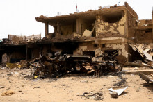Poškodené auto a budovy v Chartúme počas stretov medzi polovojenskými jednotkami rýchlej podpory a armádou. FOTO: Reuters