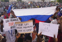 Ľudia držia transparenty a ruskú vlajku na pochode v nigerskej metropole Niamey. FOTO: TASR/AP