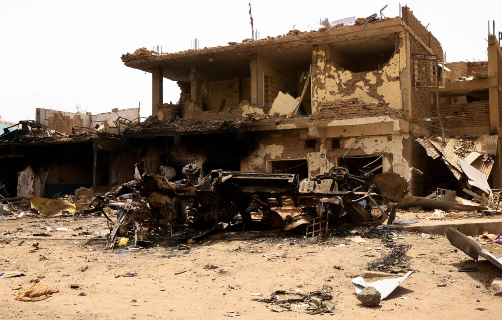 Poškodené auto a budovy v Chartúme počas stretov medzi polovojenskými jednotkami rýchlej podpory a armádou. FOTO: Reuters