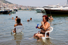 Neapolčania sa ochladzujú v mori počas horúceho letného dňa. FOTO: REUTERS