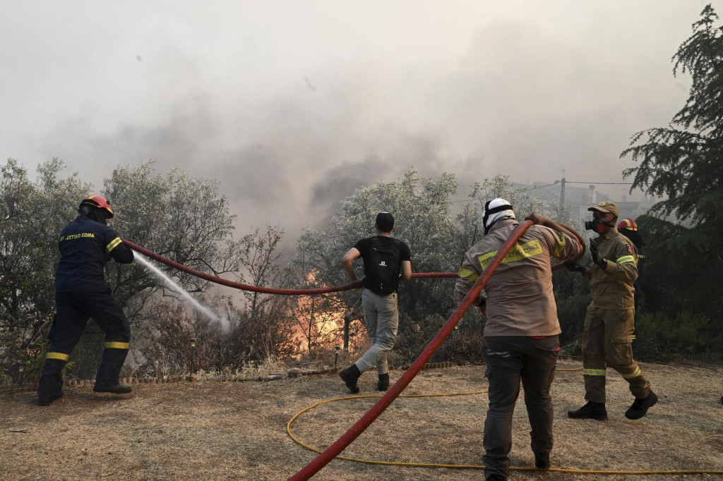 Na snímke hasiči a dobrovoľníci sa snažia uhasiť lesný požiar v meste Nea Anchialis neďaleko gréckeho mesta Volos. FOTO: TASR/AP