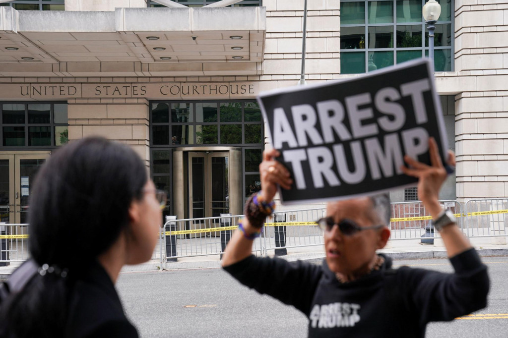Demonštrant drží transparent s nápisom ”Zatknite Trumpa”. FOTO: Reuters