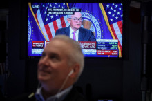 Obchodníci na Wall Street pozorne sledujú slková šéfa amerického Fedu Jeroma Powella v televízii.  FOTO: REUTERS