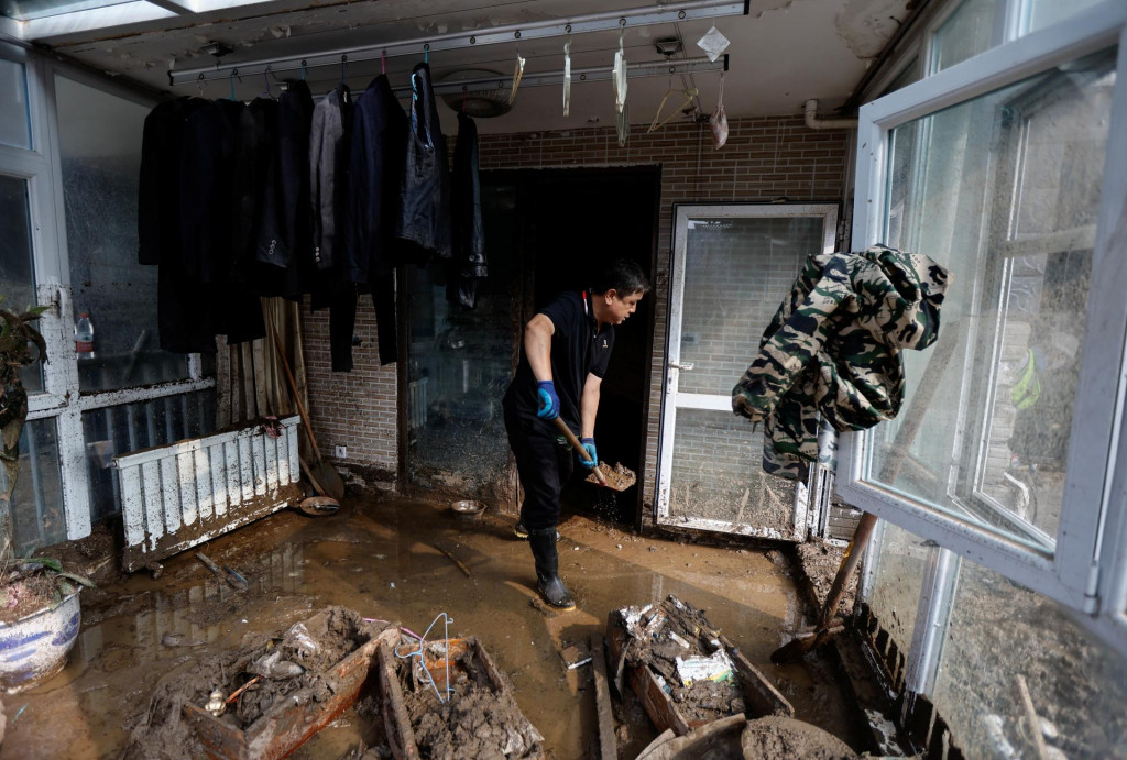 Priateľ miestneho obyvateľa menom Gao pomáha upratať jeho poškodený dom. FOTO: Reuters