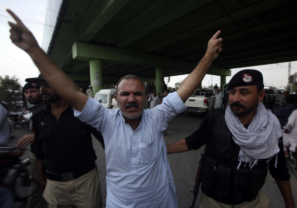 Policajti zatýkajú stúpenca bývalého pakistanského premiéra Imrana Chána. FOTO: TASR/AP