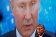 Hovorca Kremľa Dmitrij Peskov stojí pred projekciou Vladimira Putina. FOTO: Reuters