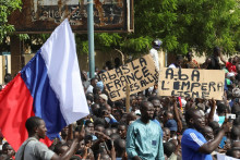 Demonštranti držia ruskú vlajku a transparenty počas zhromaždenia na podporu pučistov v nigerskom hlavnom meste Niamey. FOTO: Reuters