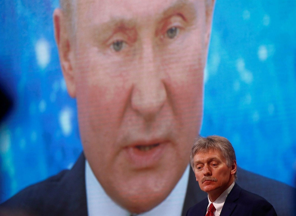Hovorca Kremľa Dmitrij Peskov stojí pred projekciou Vladimira Putina. FOTO: Reuters