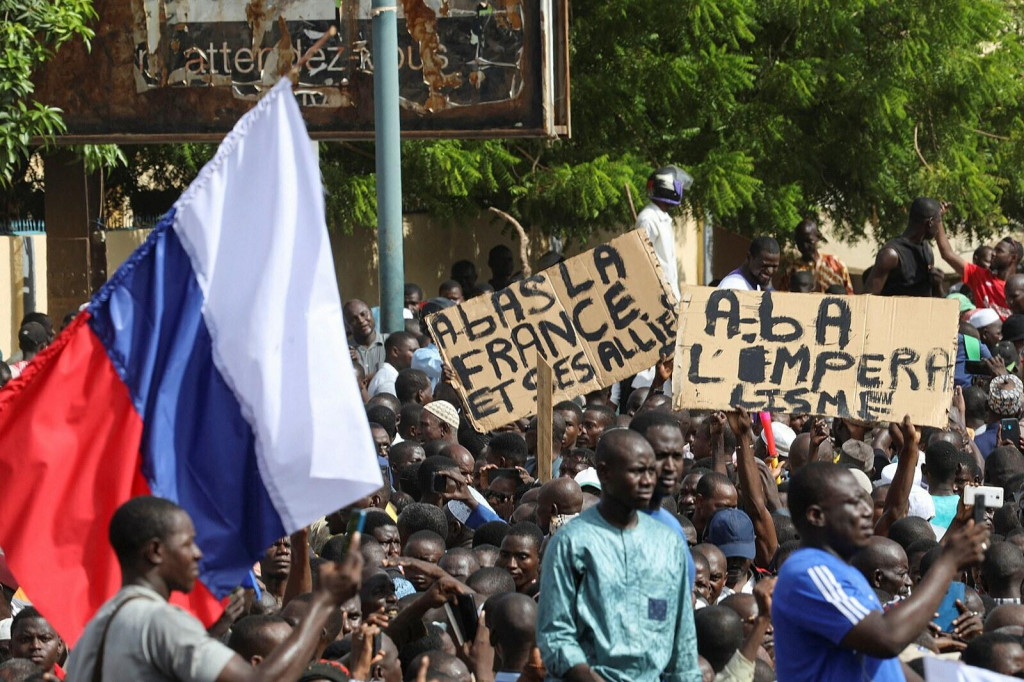 Demonštranti držia ruskú vlajku a transparenty počas zhromaždenia na podporu pučistov v nigerskom hlavnom meste Niamey. FOTO: Reuters